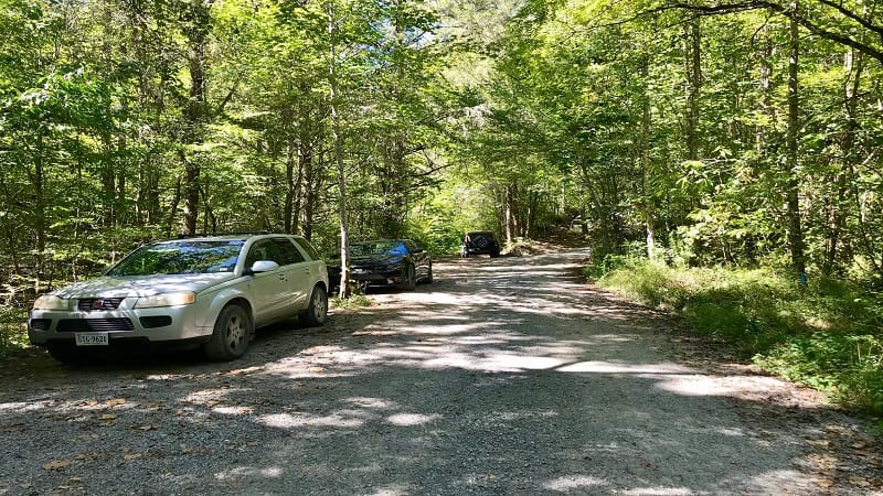 Cars parked on gravel road near Devil's Bathtub hike trailhead