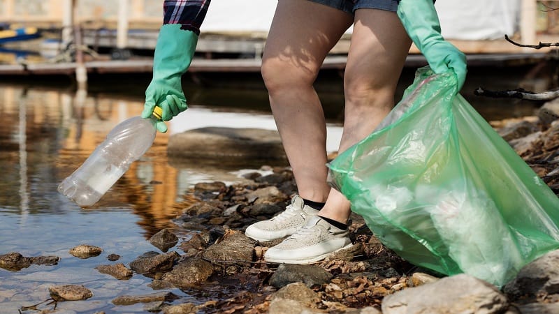 picking up trash at a pond