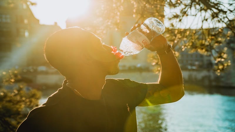 man drinking water on a hike