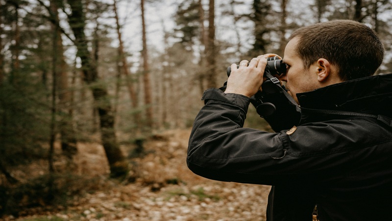 A man birdwatching with binoculars